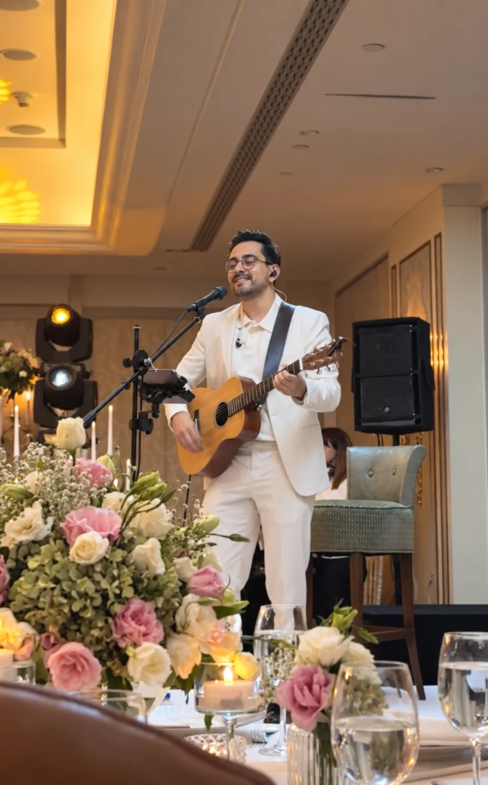 Bilal Khan performing acoustic guitar at an intimate dinner celebration